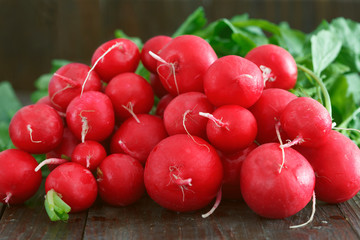 Pile of fresh red radish on wooden background