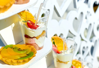 creamy dessert with strawberries and dried orange in a plastic cup