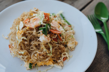 Pad Thai, stir-fried noodles in plate on the wooden table