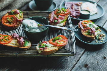 rustic breakfast, baked with basil, tomato, salami and cheese slices of bread, fried egg and bacon