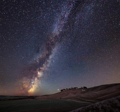 Vibrant Milky Way composite image over landscape of ancient chalk white horse at Cherhill in Wiltshire