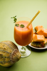 Musk melon juice with slice, also known as Kharbuj/kharbuja fruit extract, served in a glass with mint. selective focus