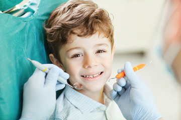 Child smiling while sitting in the dentist's chair.
