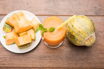 Musk melon juice with slice, also known as Kharbuj/kharbuja fruit extract, served in a glass with mint. selective focus