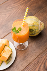 Musk melon juice with slice, also known as Kharbuj/kharbuja fruit extract, served in a glass with mint. selective focus