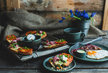 rustic breakfast, baked with basil, tomato, salami and cheese slices of bread, fried egg and bacon