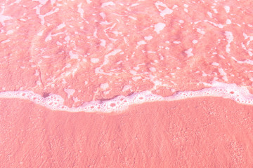 Foamy clear sea wave rolling to pink sand shore beach. Aerial view from above. Beautiful tranquil idyllic scenery. Tropical nature nautical background. Beach vacation relaxation paradise wanderlust