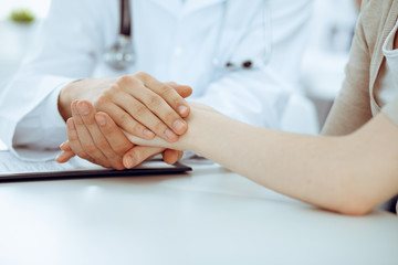 Hand of doctor reassuring her female patient. Medicine and health care concept