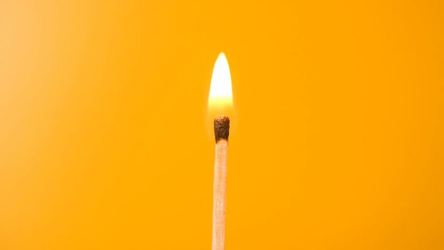 Burning match, middle view orange background HD stock footage