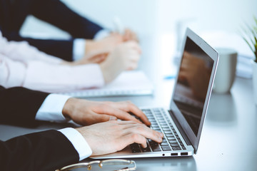 Group of business people working together in office. Man hands typing on laptop computer