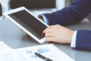 Businessman using touchpad at meeting, closeup of hands