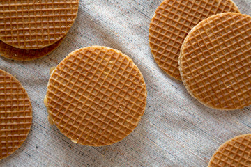 Sweet homemade Dutch stroopwafels with honey-caramel filling on cloth, overhead view. From above, flat lay, top view.