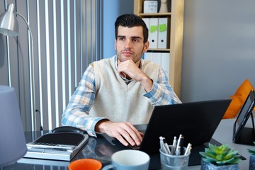 Portrait of thinking young businessman