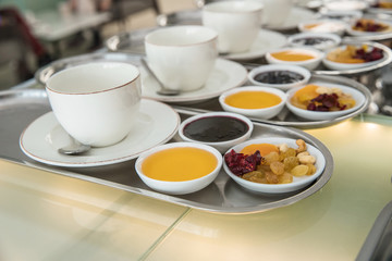 Cups of tea with dried fruits, jam and honey on separate trays, breakfast at the hotel, hanging table, restaurant - Powered by Adobe
