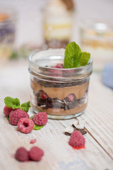 Chocolate pudding with raspberries and chia seeds, decorated with mint. crumbs of biscuits, berries. Ga wooden rustic table