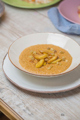 Creamy soup with a raisins on wooden table