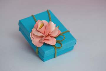 Gift package, gift in blue packing with leather ribbon and flower from paper, in a beautiful and elegant package