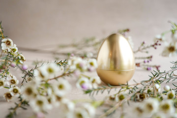 Golden plastic egg in flowers