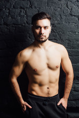 Fototapeta na wymiar Studio shot of young handsome man shirtless against black background