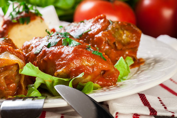 Stuffed cabbage with meat and rice served with boiled potatoes and tomato sauce