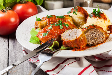 Stuffed cabbage with meat and rice served with boiled potatoes and tomato sauce