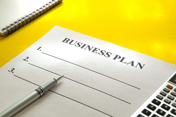 Strategy business plan with pen on yellow table.