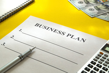 Strategy business plan with pen and money on yellow table.