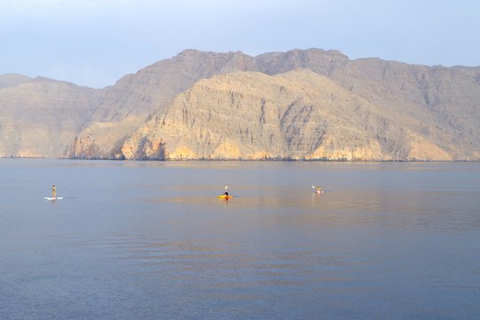 Picture of tourists with paddles and kayak and enjoying a morning activity in a spectacular environment with cristal waters between cliffs. Pure tourists paradise.
