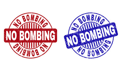 Grunge NO BOMBING round stamp seals isolated on a white background. Round seals with distress texture in red and blue colors. Vector rubber imprint of NO BOMBING tag inside circle form with stripes.