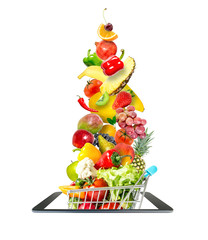 Fresh vegetables and fruits, flying, falling, into a crowded shopping cart in a modern gadget, mobile phone, isolated on a white background. Creative idea online shopping.