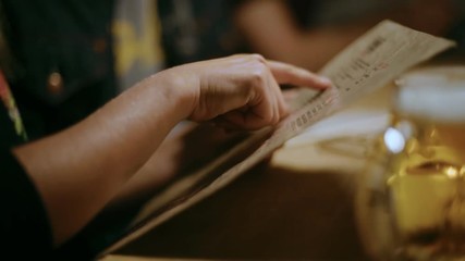 Two friends or couple discuss order in restaurant of cafe, look through menu and study different options for vegan or gluten free food or allergens. Hipster food court hang out for young people - Powered by Adobe