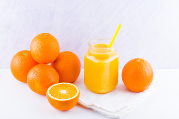 Orange fruits and juice on white background. Citrus fruit for making juice with manual juicer. Oranges on white napkin. Mason jar with orange juice