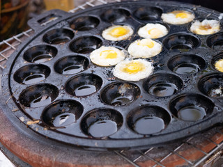 small quail's eggs fry in multi hole flat pan thai style