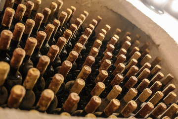 Obraz premium Wine bottles stacked up in old wine cellar