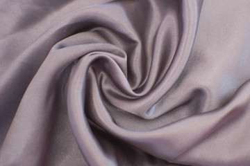 Fototapeta na wymiar Silk wrinkled gray fabric. View from above. Textile and texture concept - close up of crumpled silk gray wavy fabric background
