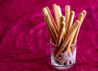 Grissini on the background a red tablecloth. Bread sticks. Italian food.
