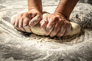 Making dough by male hands at bakery. Food concept