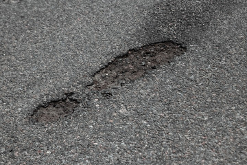 The road in disrepair with a lot of potholes. Cars go with the risk of breakdowns.
