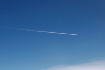 airplane flying make condensation tail on sky in sunshine day