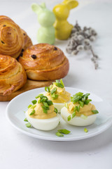 Creamy deviled eggs and sweet roll buns on festive Easter table