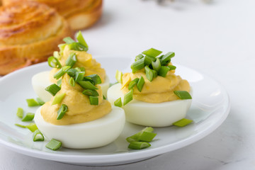 Creamy deviled eggs and sweet roll buns on festive Easter table