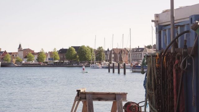 A Standing paddle surf-boarder making his way through the inner harbour of Svendborg Denmark
