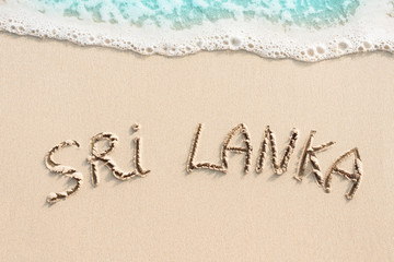 Sri Lanka handwritten on the sand, soft wave and beach background