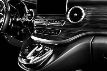 Modern Luxury car inside. Interior of a car. Comfortable leather seats. Perforated leather cockpit with white stitching. Steering wheel and dashboard. Automatic gear stick shift. Black and white