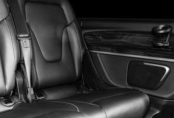 Back passenger seats in modern luxury car. Frontal view. Perforated leather with white stitching. Car detailing. Back Leather comfortable seats. Car interior details. Black and white