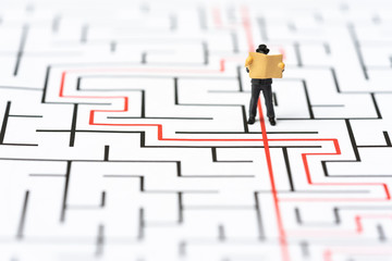 Miniature people, businessman in the labyrinth or maze figuring out the way out. Business concept,...
