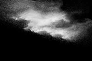 Fototapeta na wymiar Freeze motion explosion of white powder on a black background.Stopping the movement of white dust on dark background.