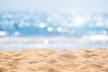 Fototapeta na wymiar Seascape abstract beach background. blur bokeh light of calm sea and sky. Focus on sand foreground.