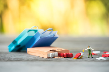 Miniature people, workers pulling out gift boxes from shopping bags. Concept of Black Friday, boxing day, year end sales.