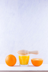 Orange fruits with juice, concept. Orange juice and halves of oranges on white background. Citrus for making juice and manual juicer. Whole and squeezed oranges and glass of juice